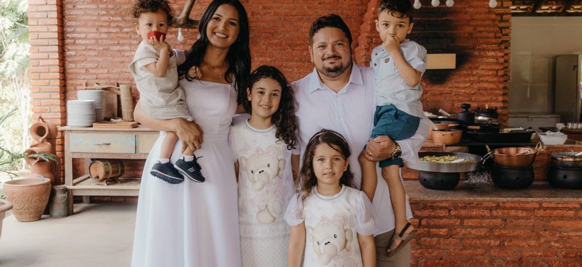 A joyful family portrait in a cozy rustic kitchen setting with a warm atmosphere.