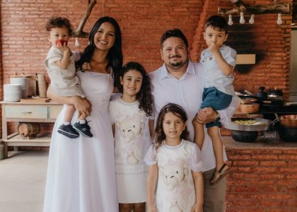 A joyful family portrait in a cozy rustic kitchen setting with a warm atmosphere.